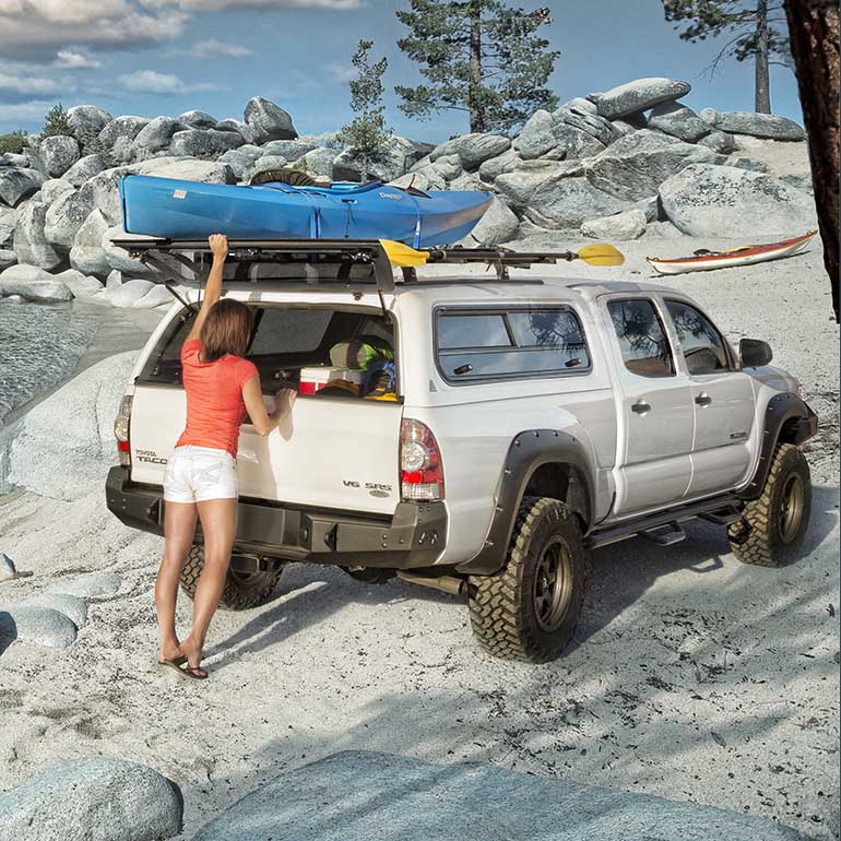 A women unpacking from a white truck by a the beach